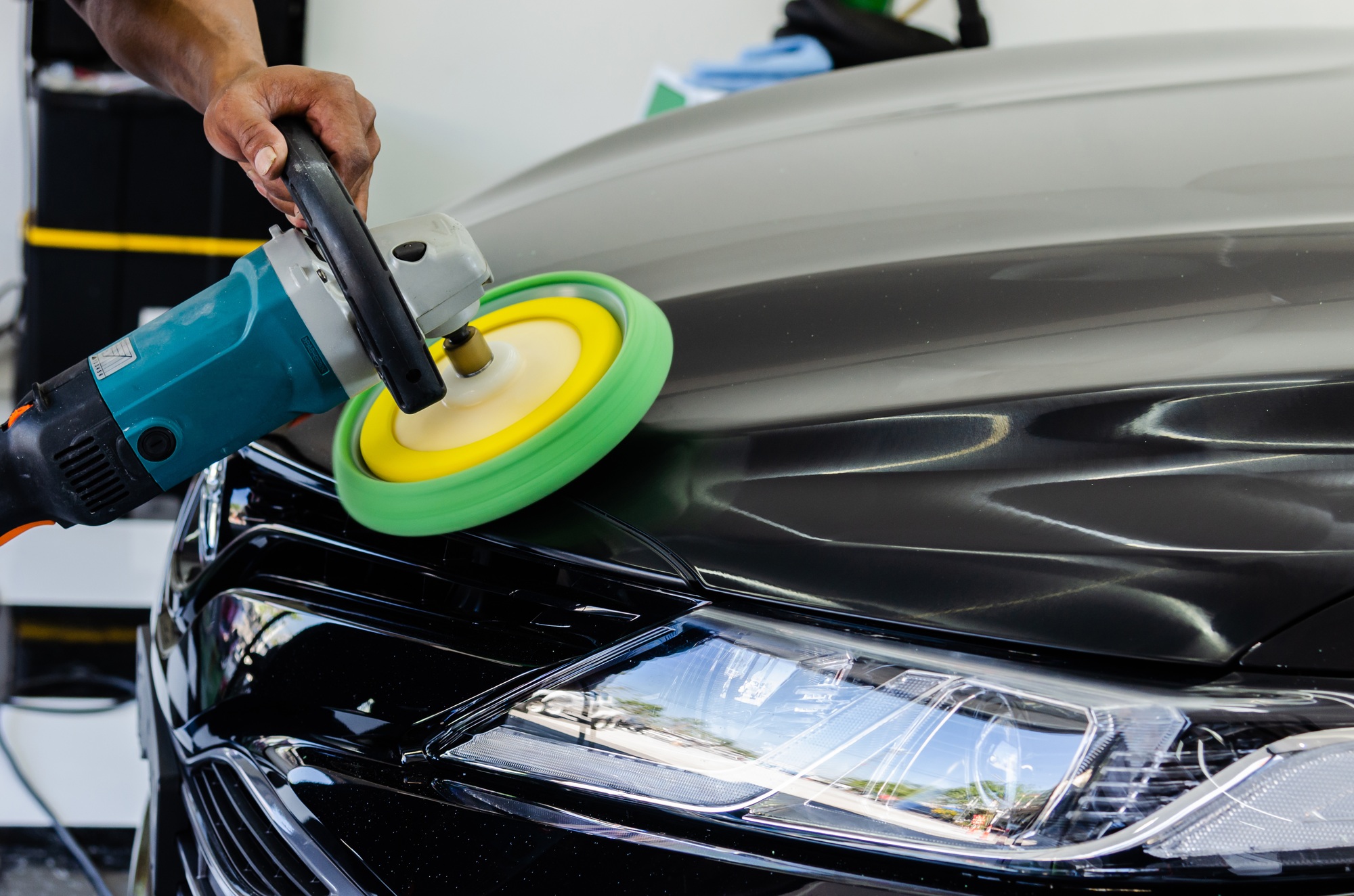 Process of polishing a black car with tools